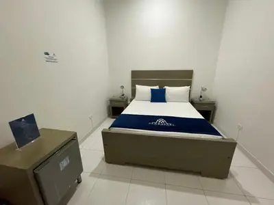 a bedroom with a bed with a blue and white blanket at Hotel Boutique San Rafael in Mariquita