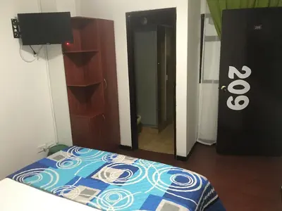 a bedroom with a bed and a closet and a door at Hostal El Eden Manizales in Manizales