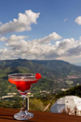 a martini glass with a cherry in it sitting on a table at Glamping la Fortuna in Girardota