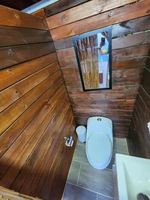a bathroom with a toilet in a wooden wall at Glamping la Fortuna in Girardota