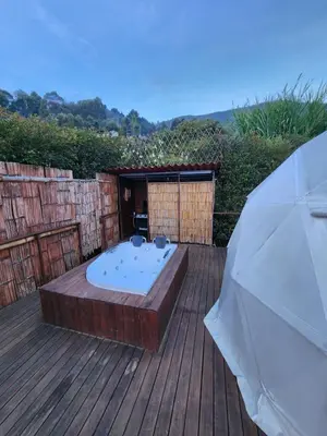 a hot tub sitting on top of a wooden deck at Glamping la Fortuna in Girardota