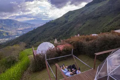 a group of people laying on a deck looking at a mountain at Glamping la Fortuna in Girardota