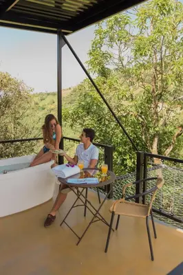a man and a woman sitting at a table on a balcony at Hotel Resort Del Cafe in Manizales