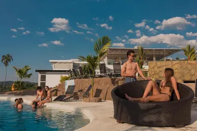 a group of people sitting around a swimming pool at Hotel Resort Del Cafe in Manizales