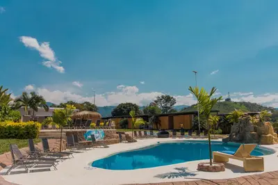 a swimming pool with lounge chairs and a resort at Hotel Resort Del Cafe in Manizales