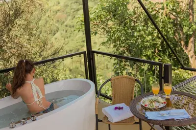 a woman sitting in a bath tub on a balcony at Hotel Resort Del Cafe in Manizales