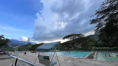 a swimming pool with people in the water at Paraíso en la ciudad in Medellín