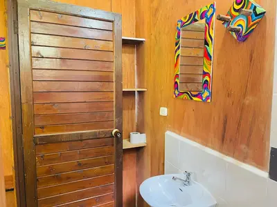 a bathroom with a sink and a wooden door at Cabañas con cascada privada & vistas a la montaña Naturaleza total in Jardin