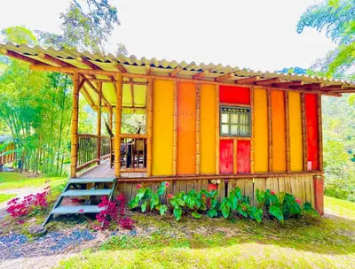 a colorful house with a fence and some plants at Cabañas con cascada privada & vistas a la montaña Naturaleza total in Jardin