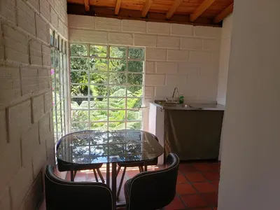 a glass table and chairs in a room with a window at Ensenillo Hotel Boutique in Rionegro
