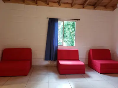 two red chairs in a waiting room with a window at Ensenillo Hotel Boutique in Rionegro