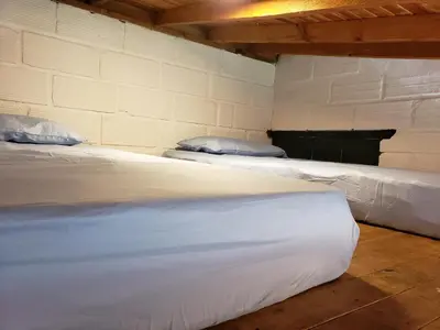 two white beds in a room with a wall at Ensenillo Hotel Boutique in Rionegro