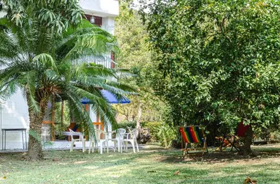 a yard with chairs and a palm tree and a house at ALDEA VACACIONAL LA FLORIDA Apto 103 Bloque 1 in Santa Fe de Antioquia