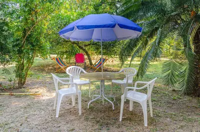 a table and chairs with a blue umbrella at ALDEA VACACIONAL LA FLORIDA Apto 103 Bloque 1 in Santa Fe de Antioquia
