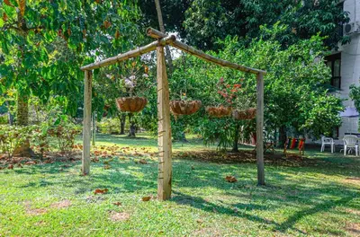 a wooden pergola with hanging baskets in a yard at ALDEA VACACIONAL LA FLORIDA Apto 103 Bloque 1 in Santa Fe de Antioquia