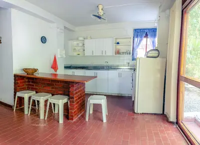 a kitchen with a table and stools and a refrigerator at ALDEA VACACIONAL LA FLORIDA Apto 103 Bloque 1 in Santa Fe de Antioquia