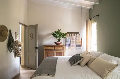 a bedroom with a bed with white sheets and pillows at Hotel Quinta Ladera in Medellín
