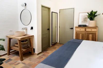 a bedroom with a bed and a table with a mirror at Hotel Quinta Ladera in Medellín