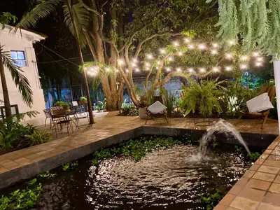 a patio with a pond and a fountain with lights at Hotel Quinta Ladera in Medellín