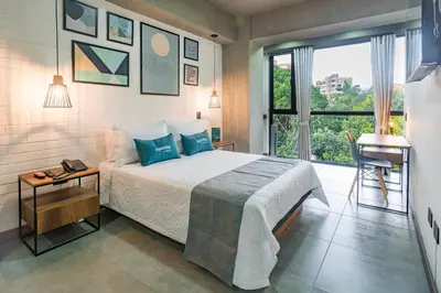 a bedroom with a bed and a window and a desk at Loft 32 Medellín Living in Medellín