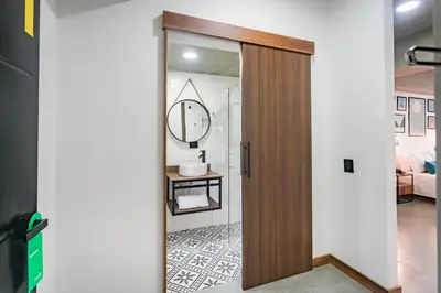 a door leading into a living room with a mirror at Loft 32 Medellín Living in Medellín