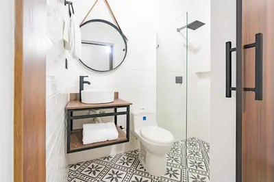 a bathroom with a toilet and a mirror at Loft 32 Medellín Living in Medellín
