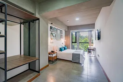 a bedroom with a bed and a large window at Loft 32 Medellín Living in Medellín