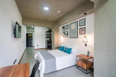 a hotel room with a bed and a table at Loft 32 Medellín Living in Medellín