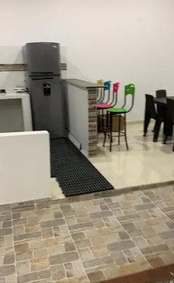 a kitchen with a counter and chairs in a room at Casa piscina in Mariquita