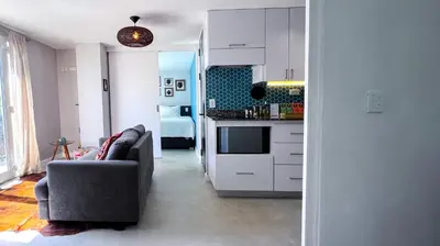 a living room with a couch and a kitchen at Casa Dodo Guatapé in Guatapé