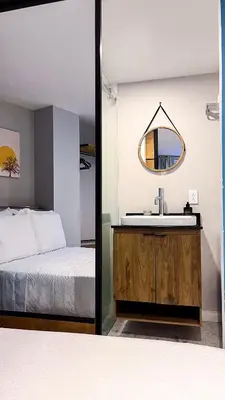 a bedroom with a bed and a sink and a mirror at Casa Dodo Guatapé in Guatapé