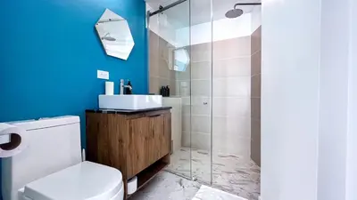 a bathroom with a toilet and a glass shower at Casa Dodo Guatapé in Guatapé