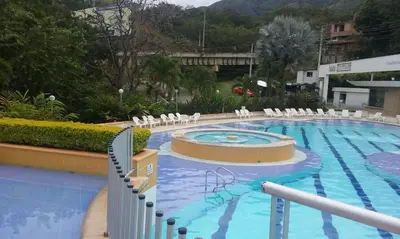a large swimming pool with white chairs in a resort at cabaña en san jeromino in San Jerónimo