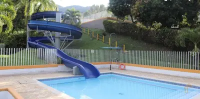 a swimming pool with a blue slide in a yard at cabaña en san jeromino in San Jerónimo