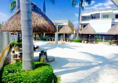 a patio with straw umbrellas and tables and chairs at cabaña en san jeromino in San Jerónimo