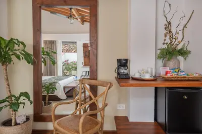 a mirror in a room with a table and a chair at Casa Bixa Hotel Boutique -Santa Fe de Antioquia- Mayores de 12 años in Santa Fe de Antioquia