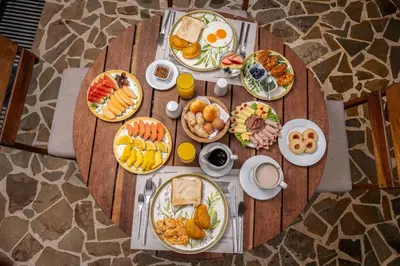 a wooden table topped with plates of breakfast food at Casa Bixa Hotel Boutique -Santa Fe de Antioquia- Mayores de 12 años in Santa Fe de Antioquia