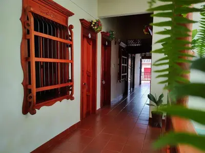 a hallway with red doors and a tile floor at La Casa de las Flores Hostal in Jardin