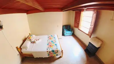 a bedroom with a bed in a room with a window at La Casa de las Flores Hostal in Jardin