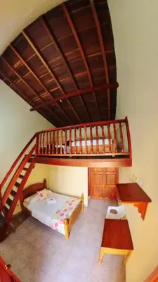 a bedroom with a bunk bed and a staircase at La Casa de las Flores Hostal in Jardin