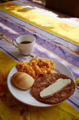 a plate of food with eggs and bread and a cup of coffee at Finca Hotel Betel in San Carlos