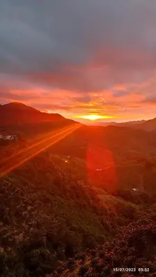 a sunset over a field with the sun setting in the distance at Finca Hotel Betel in San Carlos