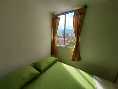 a bedroom with a green bed with a window at Apartamento Boston - Downtown - 2 hab - Wifi in Medellín