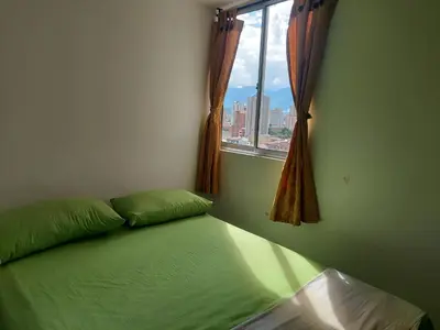 a bedroom with a green bed with a window at Apartamento Boston - Downtown - 2 hab - Wifi in Medellín