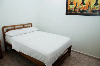 a bed in a bedroom with a painting on the wall at Hotel Casa Verde Guatapé in Guatapé