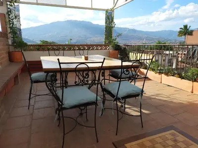 a table and chairs on a patio with a view at Villa del Prado in Medellín