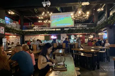 a group of people sitting at a table in a restaurant at Charming apartment in downtown – Home ARIS 301 in Medellín