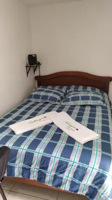 a bed with two white towels on top of it at Apartamento-Habitación Palonegro Manizales in Manizales