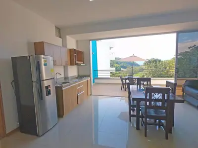 a kitchen with a refrigerator and a table with chairs at Hermoso Apartamento en San Jerónimo 3 Habitaciones PS121 in San Jerónimo
