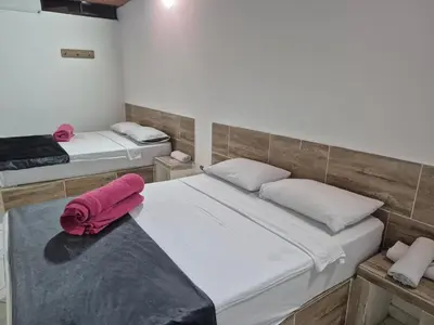 a room with two beds with pink towels on it at Hotel Brisas MEDELLIN in Medellín